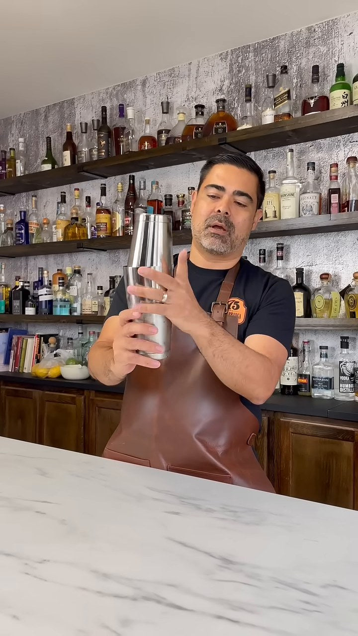 A Bar Above bartender demonstrating how to open a stainless steel Boston shaker